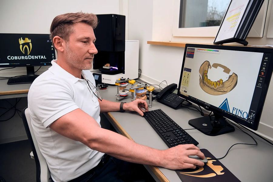 Mitarbeiter am Computer-Arbeitsplatz, auf dem Bildschirm ein 3D-Modell