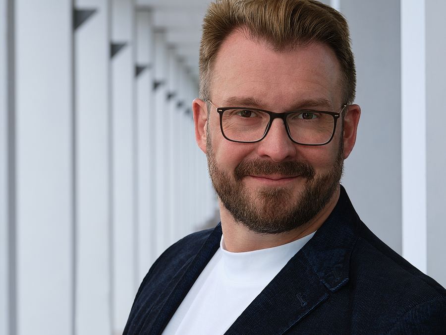 Portrait eines Mannes mit Brille und Bart im Sakko